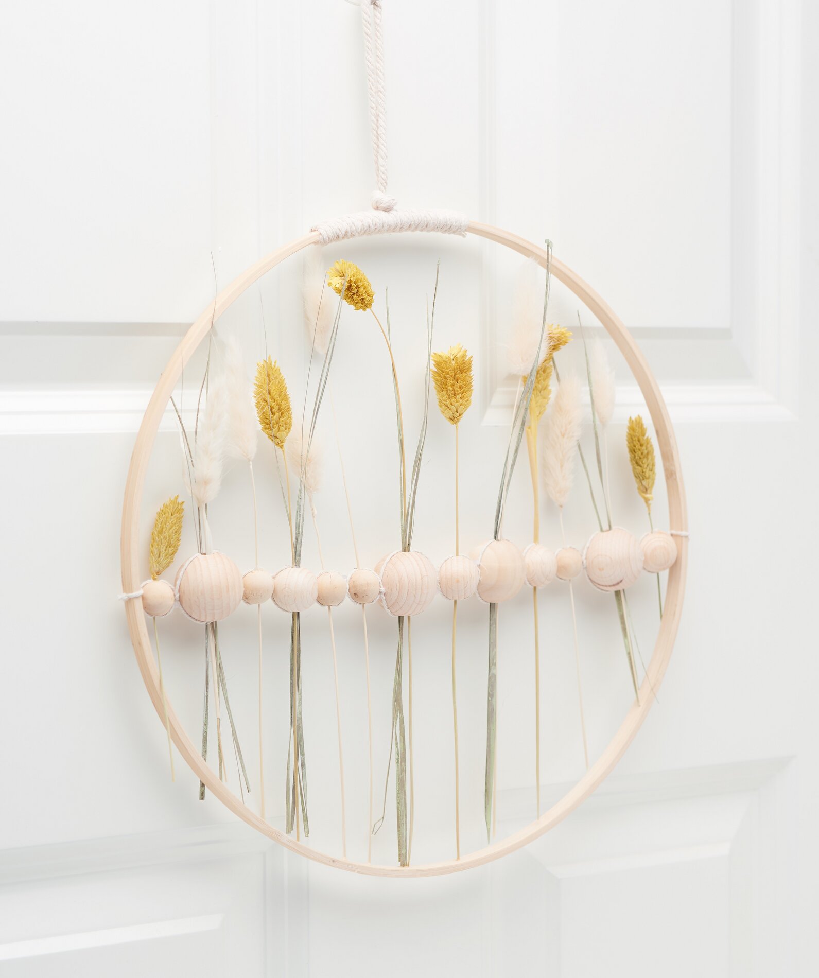 Holzring mit Holzkugeln und Trockenblumen